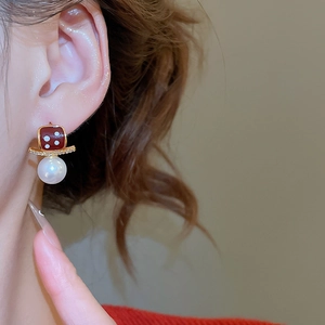 Close-up of vintage style 18K gold plated pearl earring with burgundy square detail
