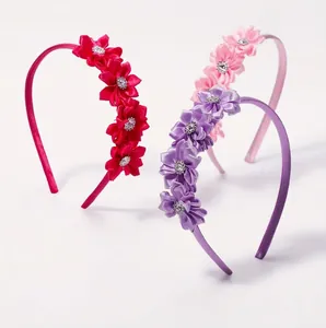 Sparkly rhinestone flower headbands for girls in vibrant red, pink, and purple colors