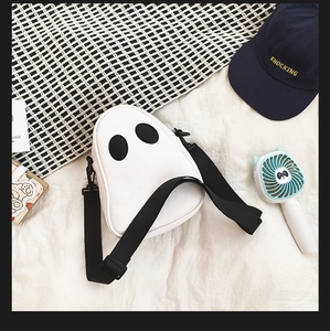 Close-up of white PU leather ghost-shaped crossbody bag with black eye detail and strap