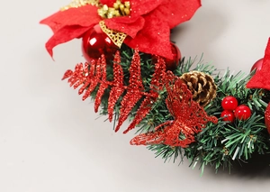 Close-up of red poinsettia fabric flowers with gold pine cones on a Christmas wreath