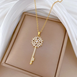 Macro view of gold flower key pendant necklace with sparkling pavé crystals