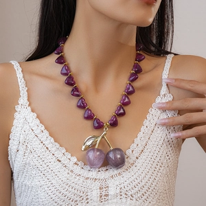 Chic purple acrylic heart beaded necklace with a sparkling double cherry pendant on a model