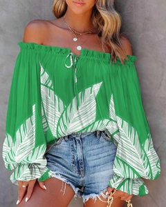 Detail of off-shoulder green blouse with white leaf patterns and puff sleeves