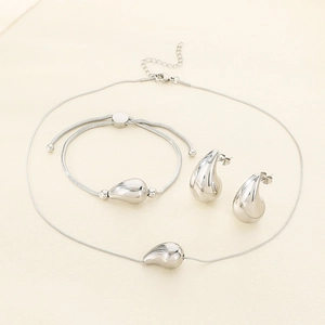Detailed view of silver teardrop jewelry set with necklace bracelet and stud earrings