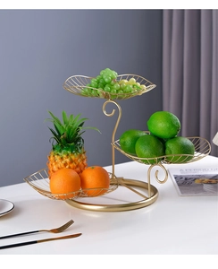Detail of three-tier golden leaf-shaped metal fruit basket with elegant wire design
