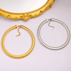 Detailed top view of gold and silver snake bone choker necklaces on a purple background