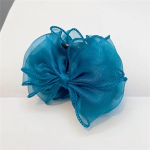 Close-up of translucent blue organza bow hair claw clip with delicate fabric texture