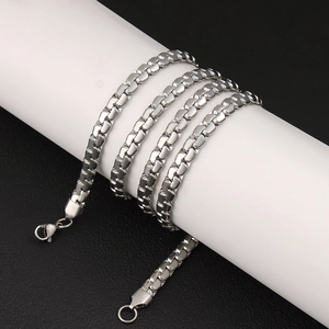 Close-up of polished silver stainless steel box chain necklace on a display stand