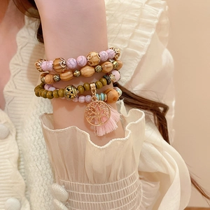 Detail of bohemian layered sandalwood beads with pink tassels and Tree of Life charm