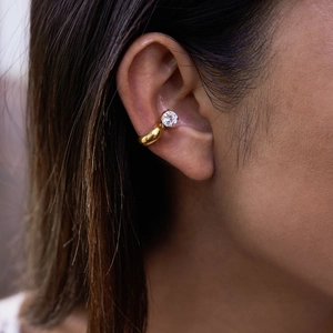 Macro shot of gold-plated stainless steel ear cuff with sparkling zircon on model ear