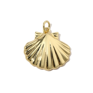 Detailed close-up of a golden shell pendant with textured radial stripes on a white base