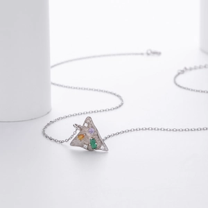 Detailed macro view of an S925 silver necklace with a triangle pendant and colorful gems