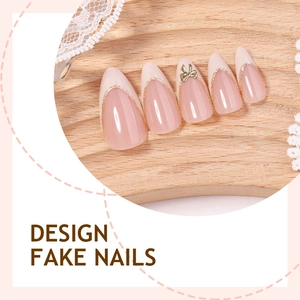 French almond fake nails with pink base, white tips, gold glitter edges and bow charm