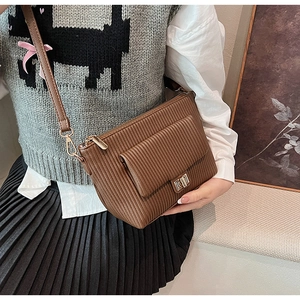 Détail de sac bandoulière marron plissé avec fermoir doré et bandoulière réglable