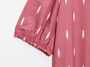 Détails des poignets élastiqués froncés sur une robe violette à imprimé feuilles blanches