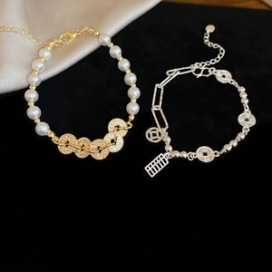 Detail of pearl bracelet with gold zircon links and silver chain featuring abacus and coin charms