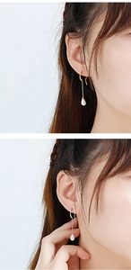 Detail of elegant gold and silver water-drop pearl tassel earrings worn by a model