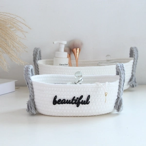 Detail of white cotton rope storage baskets with gray handles and beautiful text print