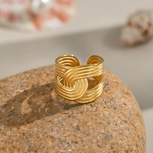 Minimalist 18K gold multi-layer textured open ring on natural stone background