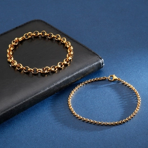 Golden stainless steel O-link chain bracelets on a dark background with leather wallet