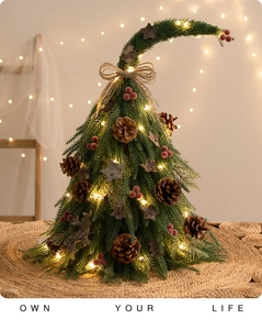Close-up of mini Christmas tree with pine cones, red berries and warm LED lights