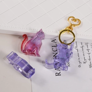 Detail of purple glitter resin cat pendant with a golden heart-shaped keychain clasp