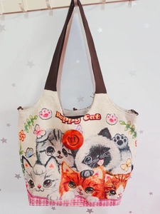 Detail der Ethno-Tragetasche mit besticktem Happy Cat-Muster und großem Knopf