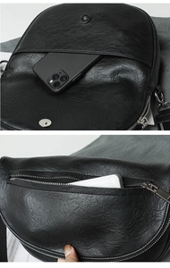 Detail view of smooth black faux leather crossbody bag with functional zip pockets
