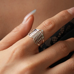 Macro shot of silver hollow geometric wave ring featuring a minimalist split V-shape design