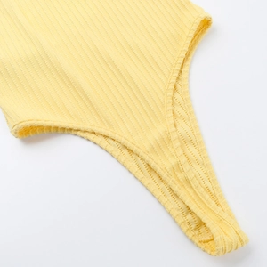 Detailed macro view of yellow ribbed jacquard fabric and high-cut seam on sports jumpsuit