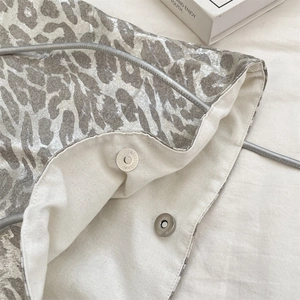 Detailed view of silver leopard print bag with magnetic closure and canvas lining