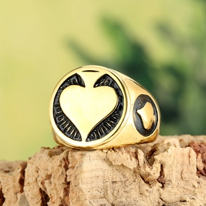 Retro black and gold heart signet ring for men on a rustic wood bark display