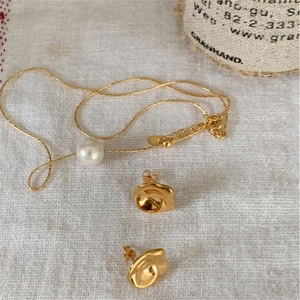 Detailed shot of 925 silver pearl necklace and irregular wave stud earrings set on linen