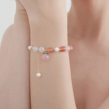 Detail shot of a beaded bracelet with freshwater pearls and pink crystal on a wrist
