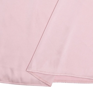 Close-up of pink fabric texture and high-quality stitching on a summer dress
