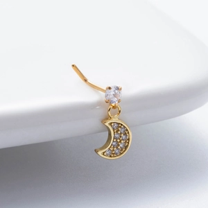 Detailaufnahme eines goldenen Nasensteckers mit Zirkonia-Mond und Stern-Anhänger