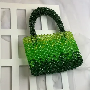 Detail of the green gradient beaded handbag with faceted acrylic beads and woven handle