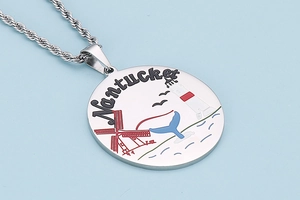 Detail of silver whale tail and lighthouse pendant on twisted chain necklace