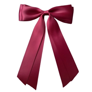 Detail of burgundy satin double-layered bow hair clip with smooth silk texture