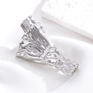Close-up of silver bouquet brooch with metallic luster on white silk background