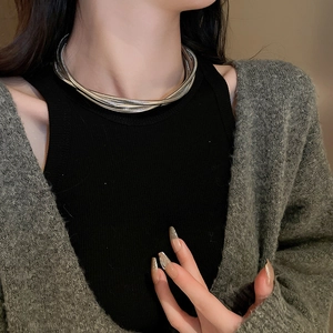Detail of multi-layer silver snake chain necklace styled on a model for a modern look