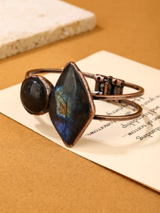 Macro detail of vintage copper bangle with blue labradorite and black natural stones