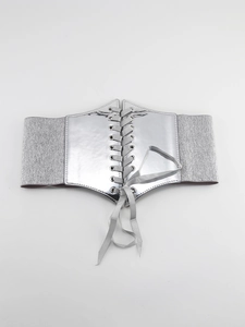 Detail view of silver mirror finish PU elastic waist belt with lace-up back design