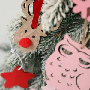 Rustic wooden Christmas ornaments with owl and star hanging on a snowy festive tree