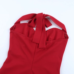 Detail view of the red halter neck dress showing the bow-tie knot and smooth fabric texture