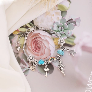 Silver snake chain charm bracelet with colorful star and heart pendants on white silk