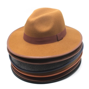 Gros plan de chapeaux fedora en feutre empilés avec rubans en couleurs neutres