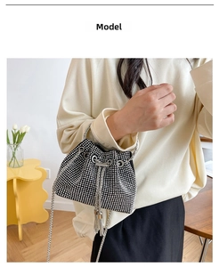 Detail of black drawstring bucket bag featuring silver rhinestones and chain strap