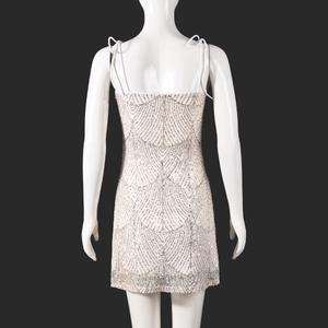 Détail de robe à paillettes argentées avec bretelles croisées et dos nu sensuel