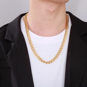Men's bold golden stainless steel Cuban link chain necklace worn by a male model